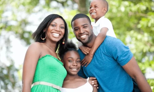 two smiling parents with young children