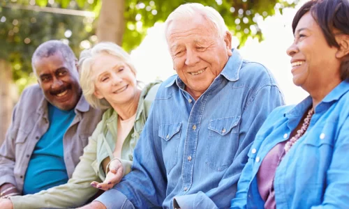 smiling senior citizens sitting on a bench